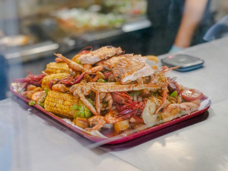 The Gulf Blogs A delicious seafood boil platter with crab, shrimp, corn, and vegetables in a vibrant setting.